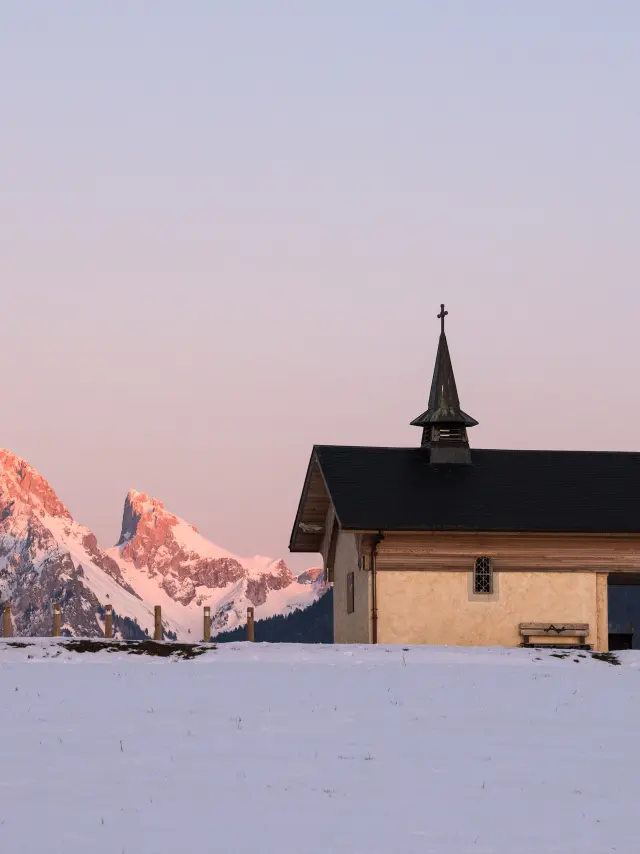 La chapelle de Champeillant en hiver, au coucher de soleil avec la Dent d'Oche enneigée en arrière plan.