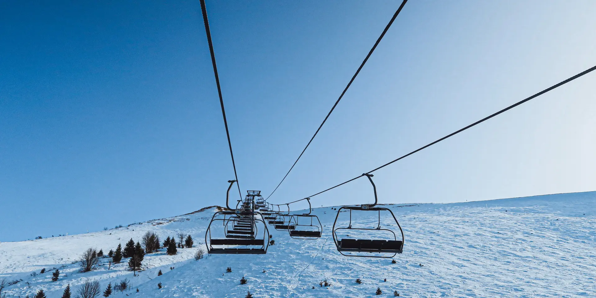 Les remontées mécaniques de Bernex sous la neige et un grand ciel bleu