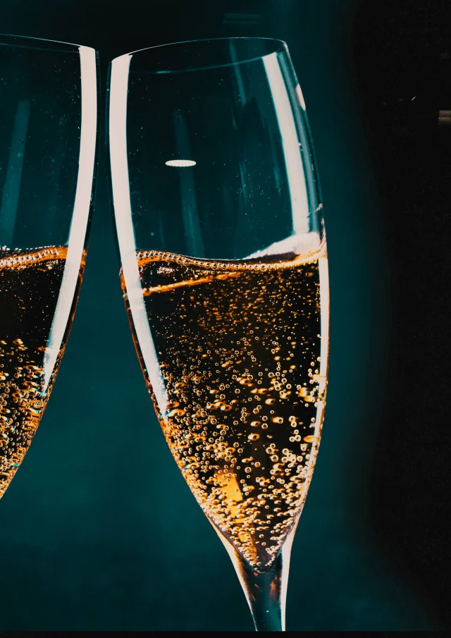 two glasses of champagne and holiday lights - new year celebration