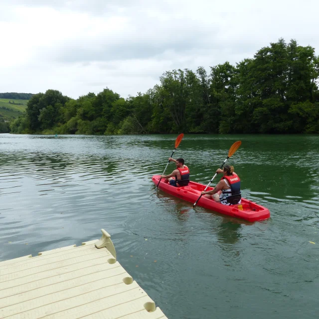Deux personnes dans un canoë rouge sur la rivière Marne à Jaulgonne.