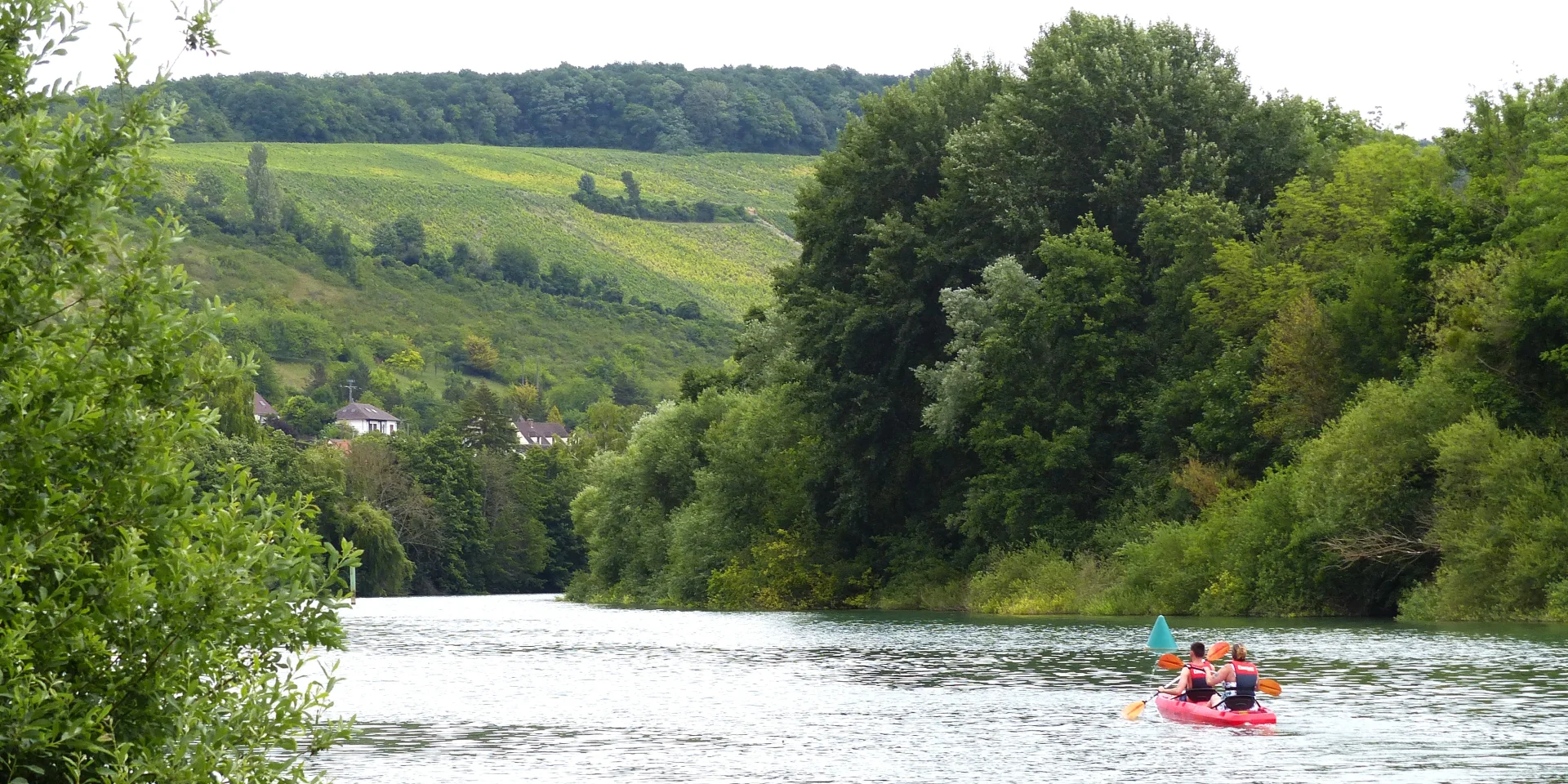 Deux personnes dans un canoë rouge sur la rivière Marne à Jaulgonne