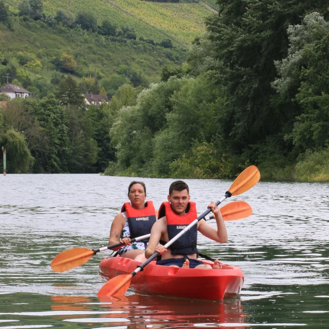 Deux personnes dans un canoë rouge sur la rivière Marne à Jaulgonne