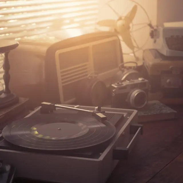 Vintage retro revival objects and appliances assortment on a table, turntable record player on the foreground
