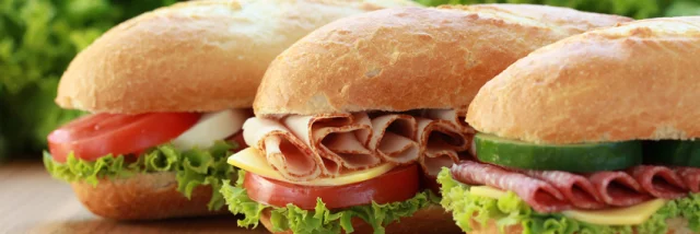 Drei Sandwiches sind belegt mit Schinken, Salami und Mozzarella