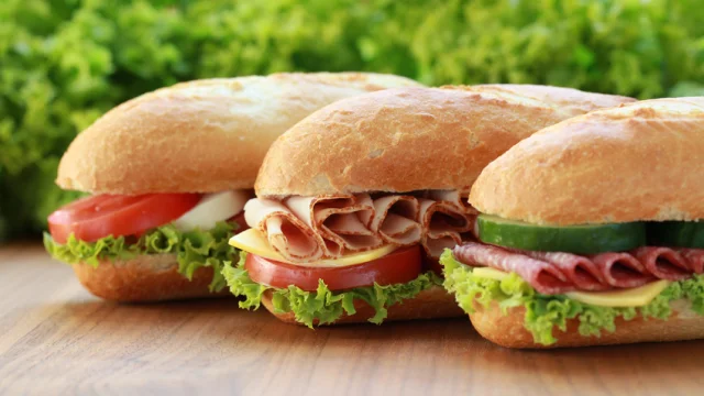 Drei Sandwiches sind belegt mit Schinken, Salami und Mozzarella