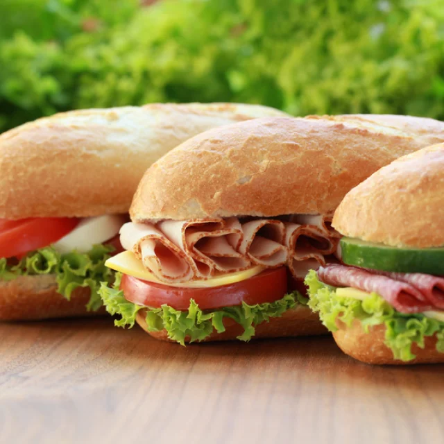 Drei Sandwiches sind belegt mit Schinken, Salami und Mozzarella