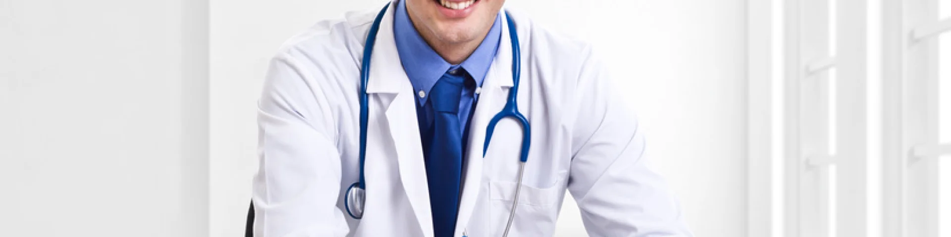 Doctor writing a prescription at his desk