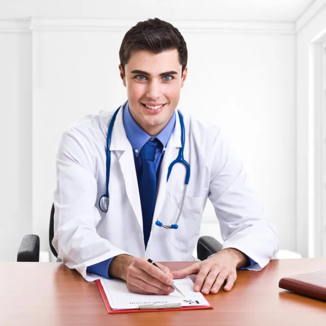 Doctor writing a prescription at his desk