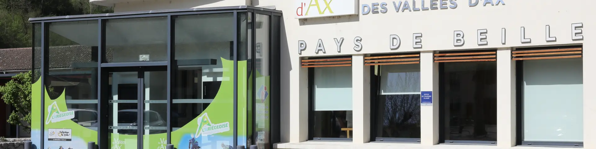 Bâtiment avec une entrée vitrée et des panneaux d'information touristique