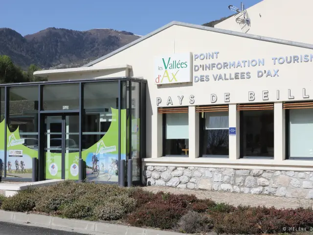 Bâtiment avec une entrée vitrée et des panneaux d'information touristique