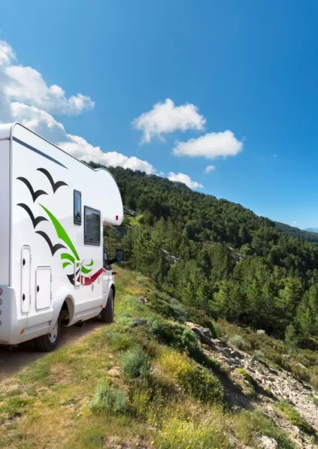 Motorhome parked on the side of a mountain road with bicycles at the back