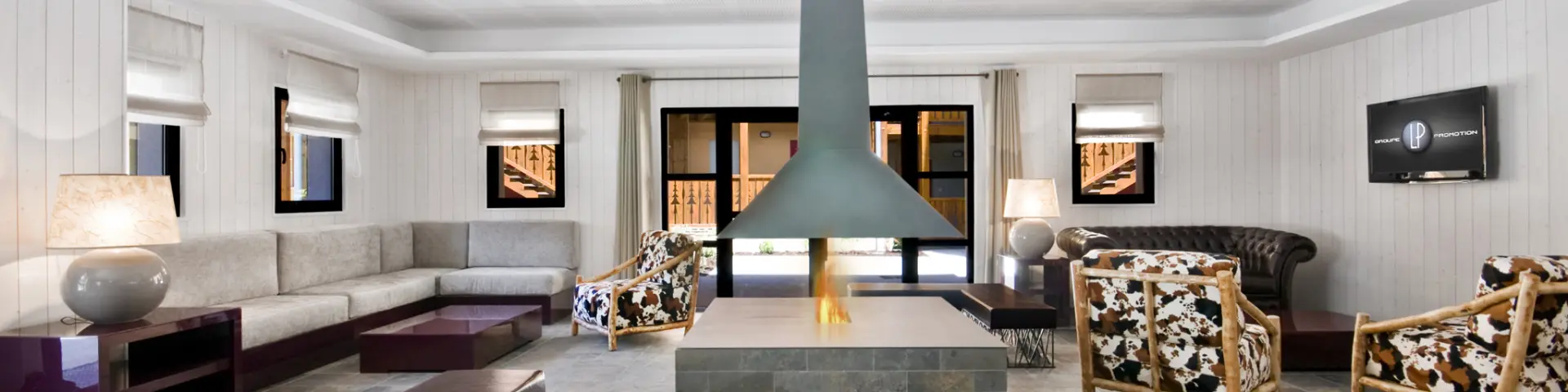 Modern living room with central fireplace, sofas and armchairs