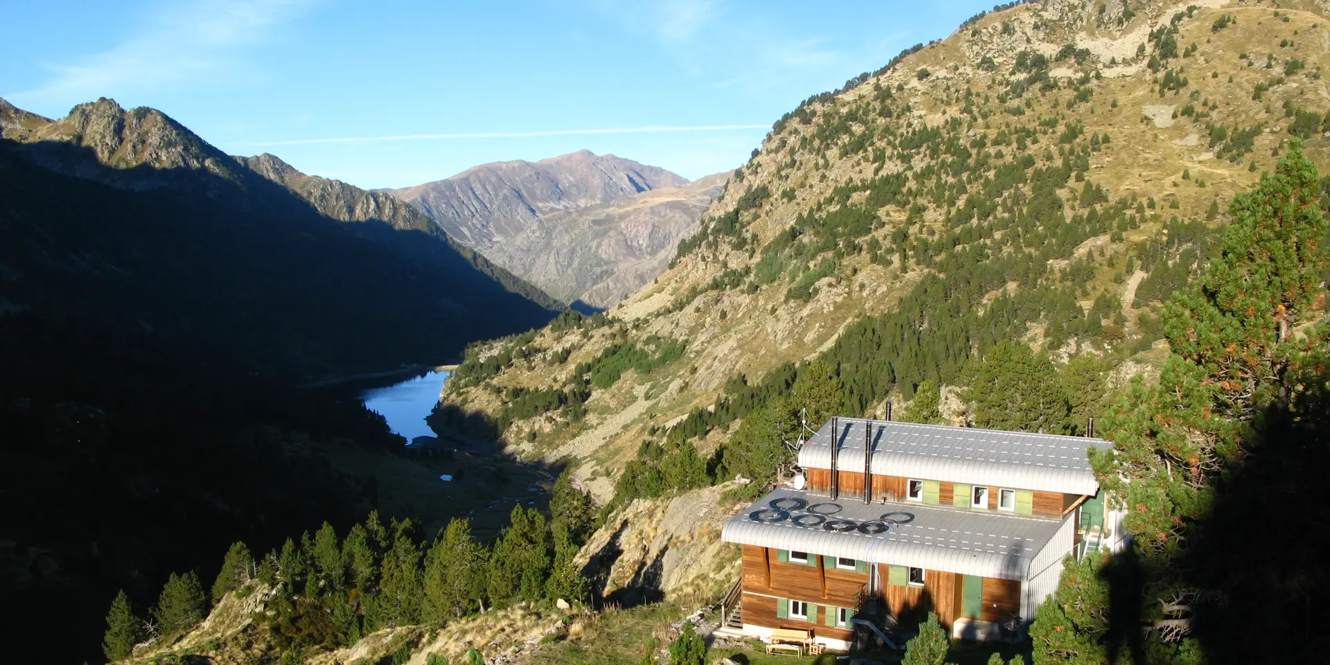 Un refuge de montagne isolé entouré de paysages montagneux et d'un lac