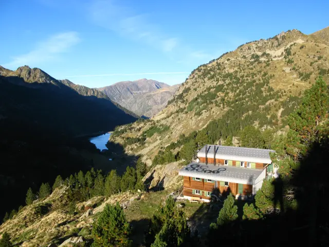 Un refuge de montagne isolé entouré de paysages montagneux et d'un lac