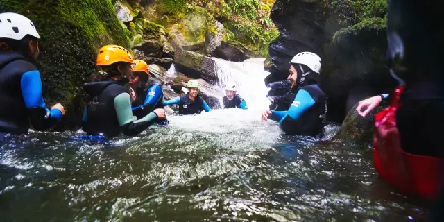 Groupe de personnes en combinaison et casque dans une rivière