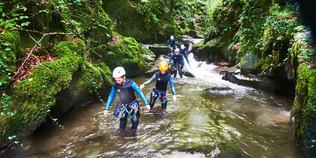 Groupe de personnes en canyoning dans une rivière