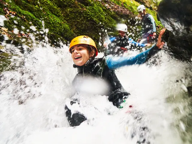 Personnes pratiquant le canyoning dans une rivière avec des cascades