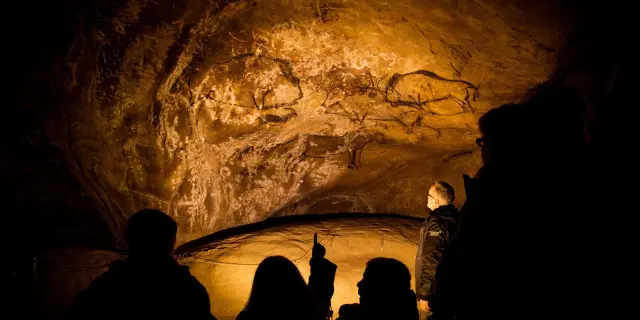 Groupe de personnes observant des peintures rupestres dans une grotte