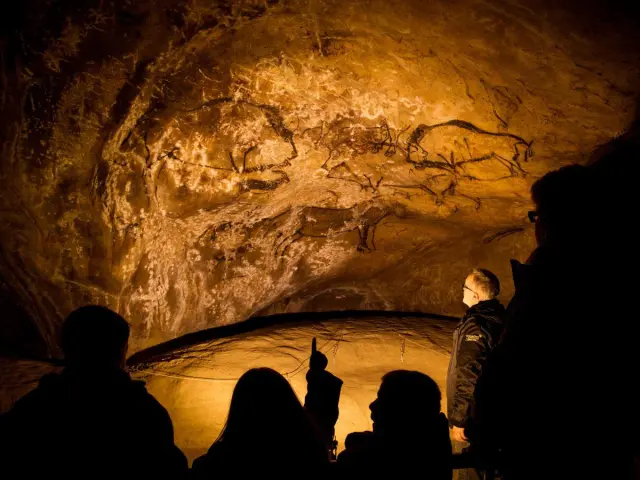 Groupe de personnes observant des peintures rupestres dans une grotte