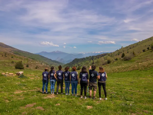 A group of people hiking in a green valley