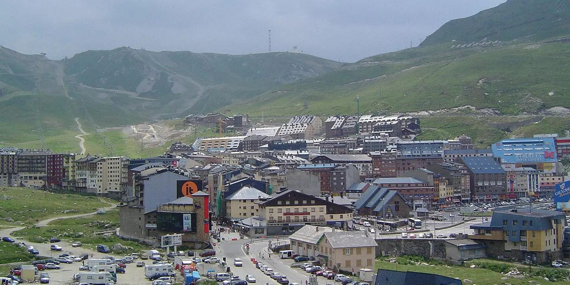 Panoramic view of an alpine ski resort with buildings and cars