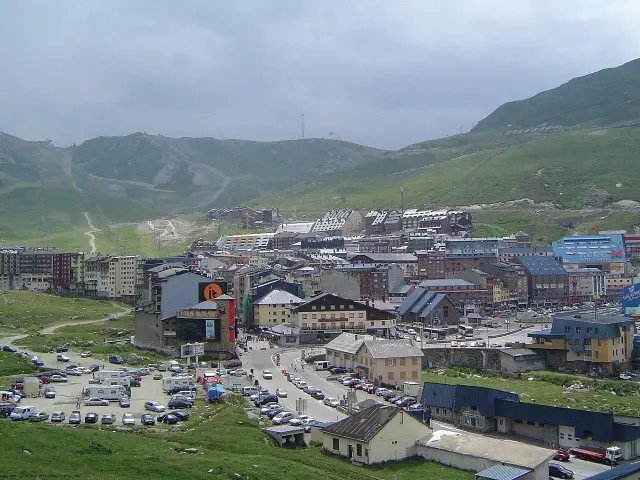 Panoramic view of an alpine ski resort with buildings and cars