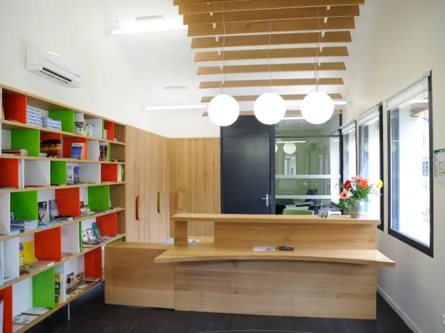 Interior of a library with colorful shelves and a wooden reception desk