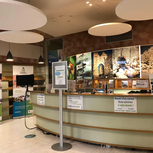 A tourist reception desk with posters and information