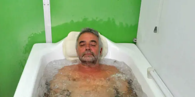 Homme âgé dans un bain à remous avec de l'eau trouble