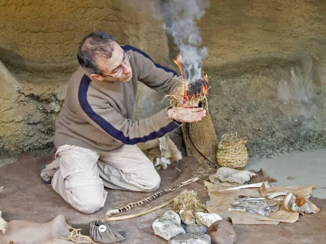 Un homme prépare un feu traditionnel avec des outils anciens