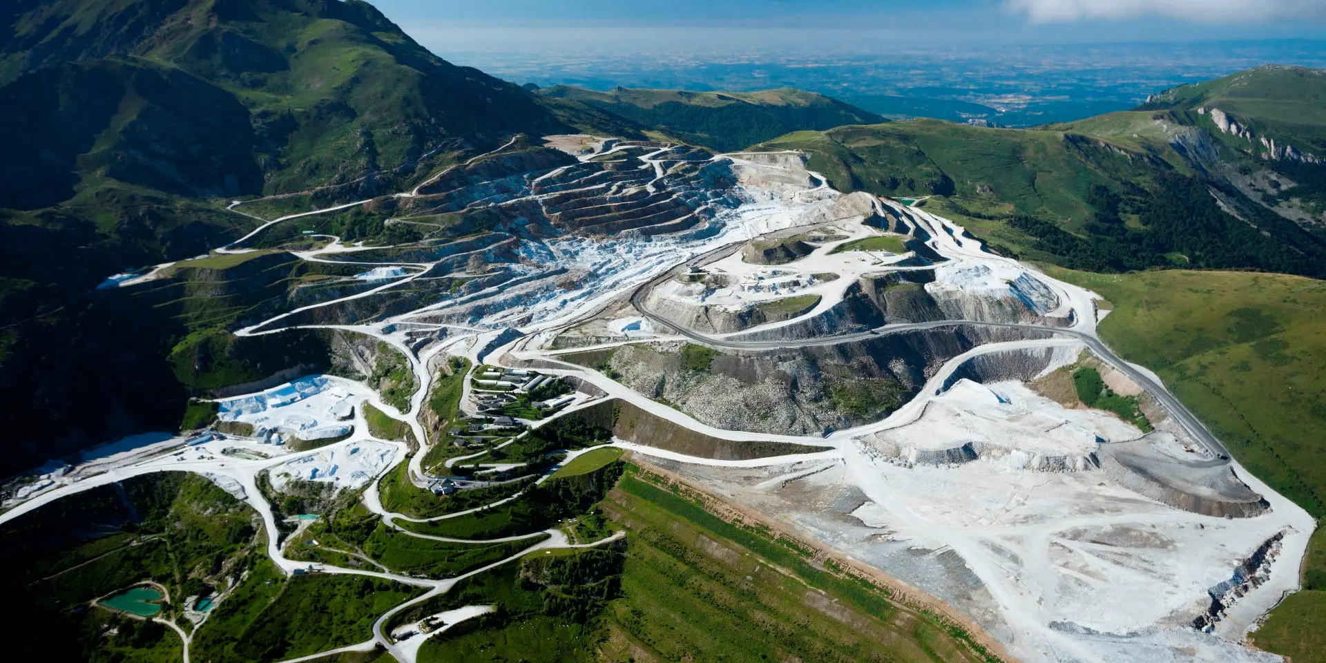 Aerial view of a mountain quarry with winding roads and extraction areas