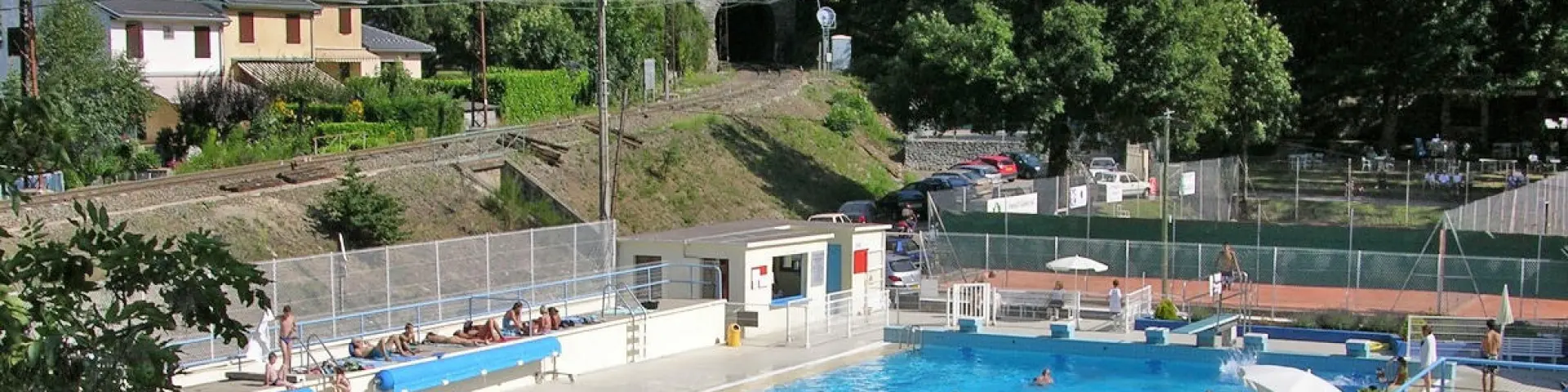 Outdoor swimming pool with people swimming and relaxing