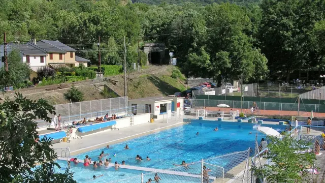 Piscina al aire libre con personas nadando y relajándose