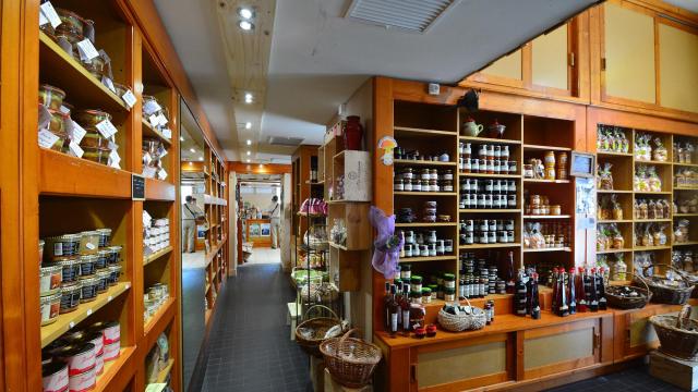 Étagères en bois remplies de pots et de bouteilles de produits artisanaux