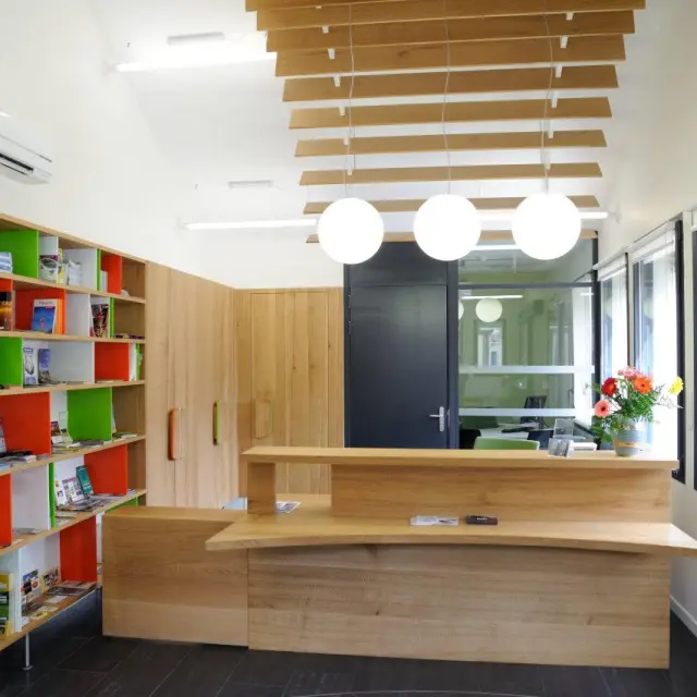 Interior of a library with colorful shelves and a wooden reception desk