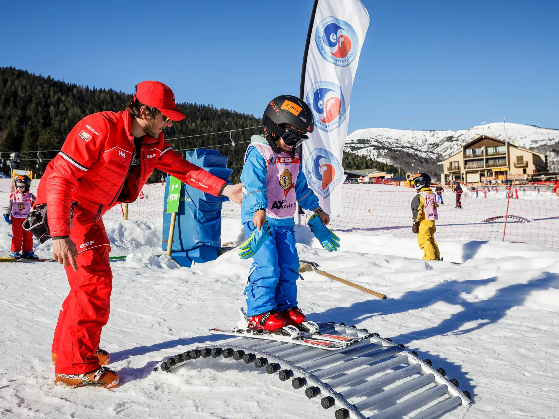 A ski instructor helps a child ski on a snowy slope