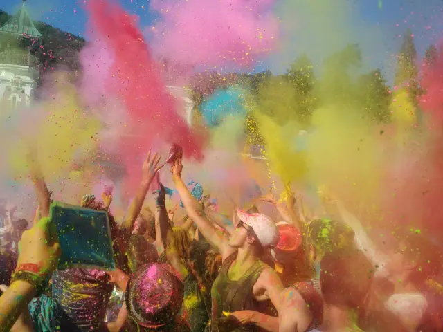 Groupe de personnes lançant des poudres colorées lors d'une fête des couleurs