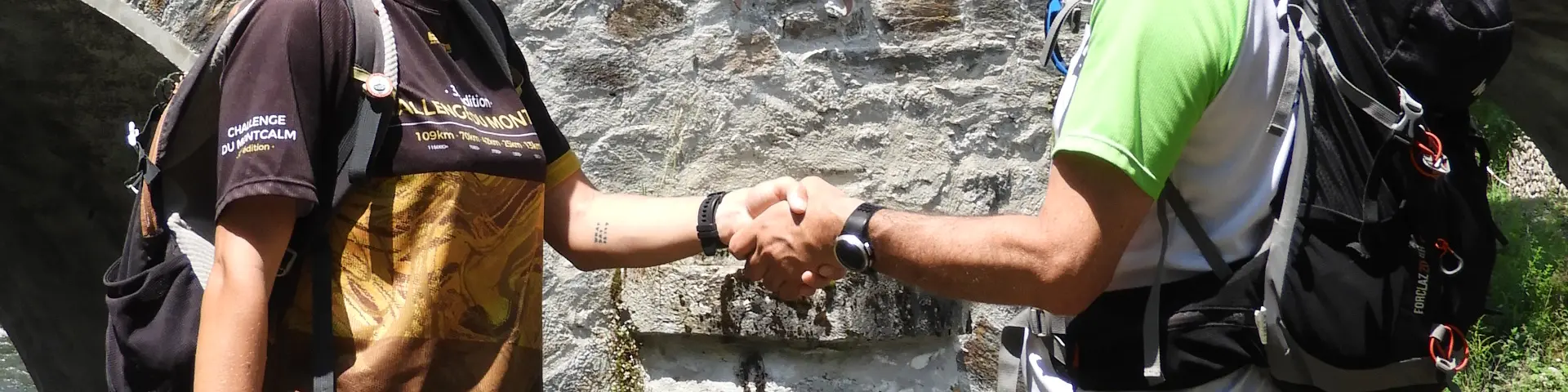 Deux personnes se serrent la main près d'une rivière