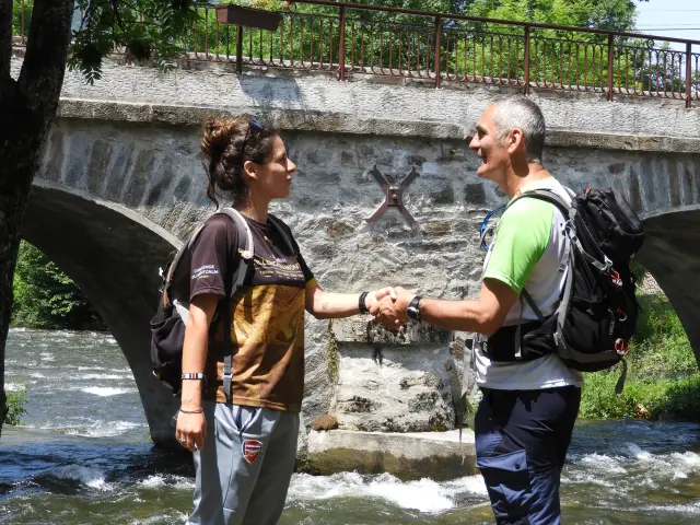 Deux personnes se serrent la main près d'une rivière