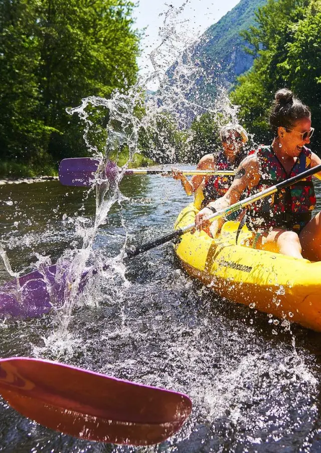 Trois personnes pagayant en kayak sur une rivière