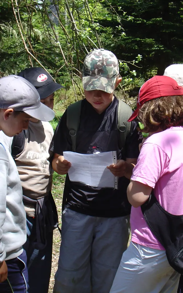 Groupe d'enfants en randonnée examinant une carte