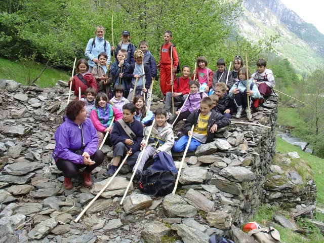Group of children and adults hiking with sticks