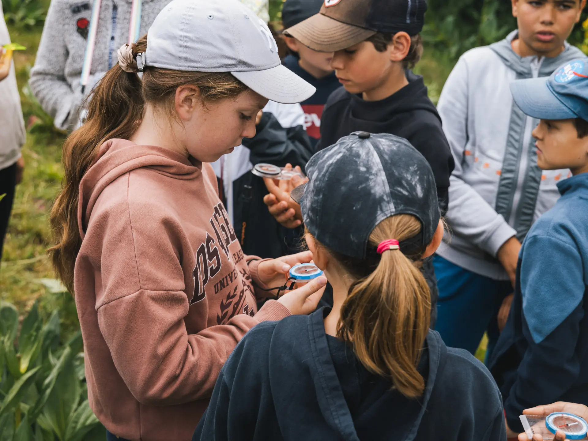A group of children observing insects with magnifying glasses