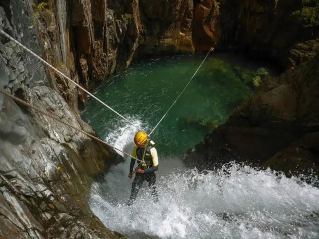 Personne en rappel le long d'une paroi rocheuse avec une corde