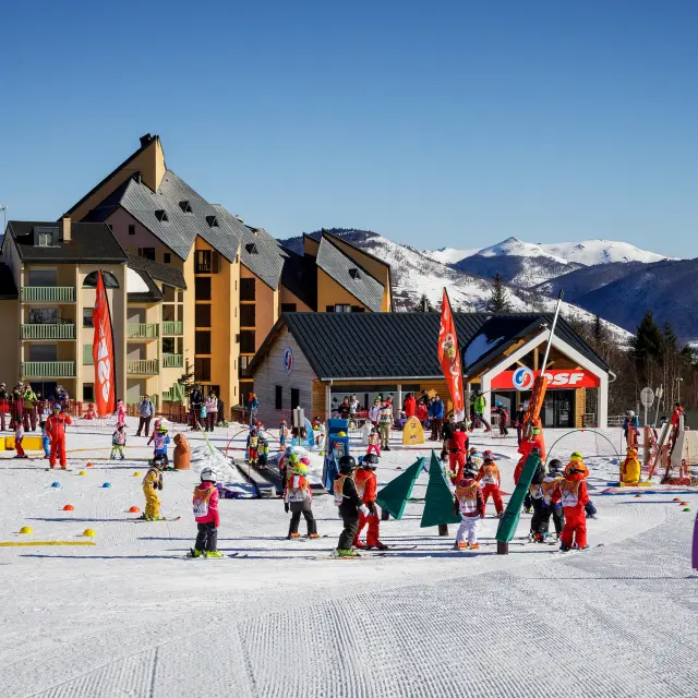 Enfants en cours de ski avec des instructeurs dans une station de ski