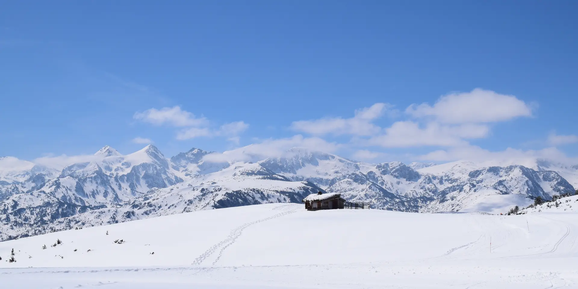 Wooden cabin in the middle of a snowy mountainous landscape
