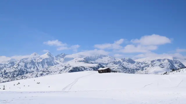 Cabane en bois au milieu d'un paysage montagneux enneigé