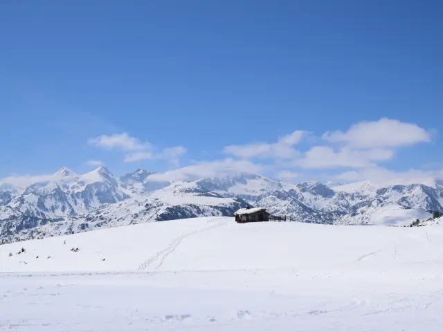 Cabane en bois au milieu d'un paysage montagneux enneigé