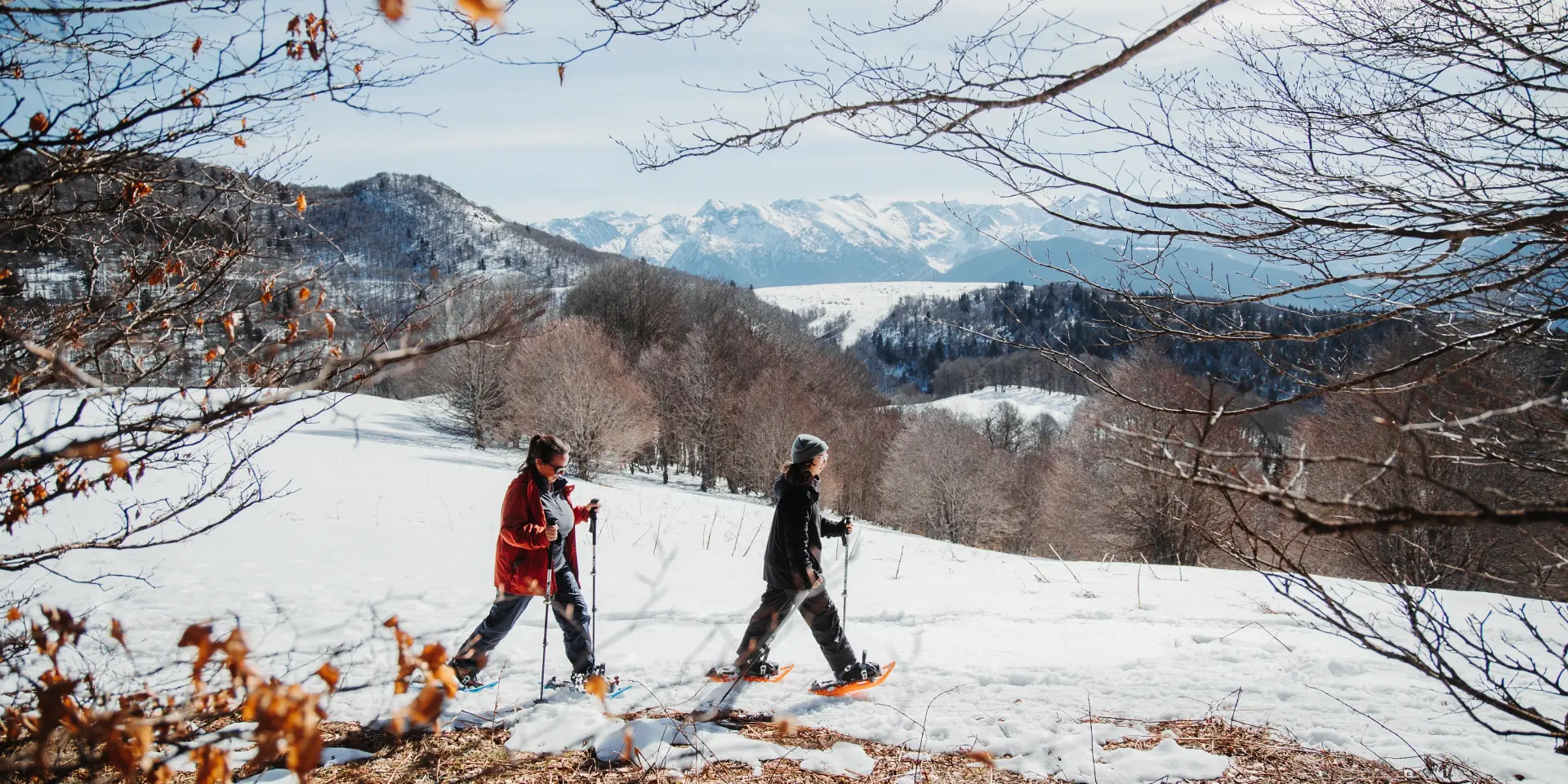 Two people snowshoeing in a snowy landscape