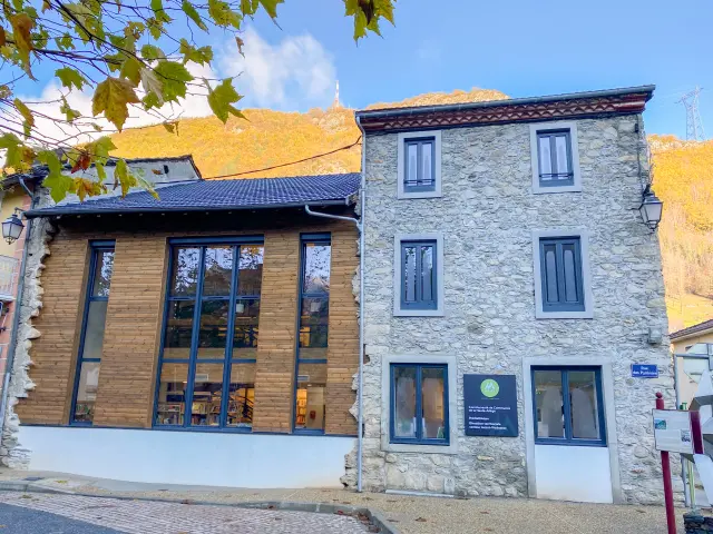 Bâtiment en pierre avec une façade moderne et des panneaux d'accessibilité
